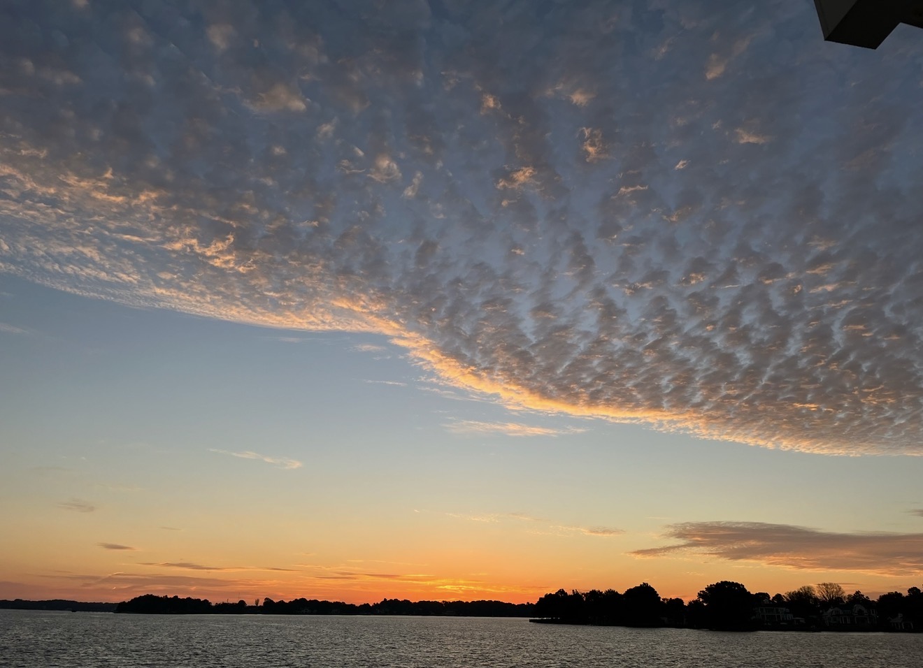 Rippled clouds lit gold over Lake Norman at sunset